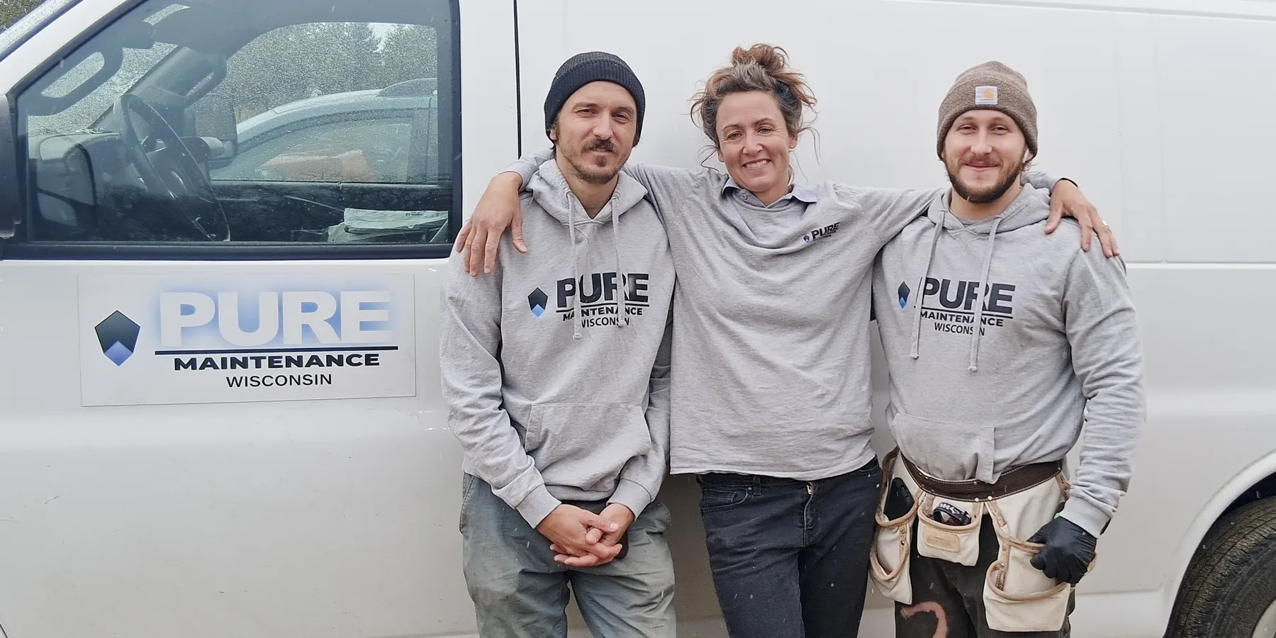 Courtney Jarman with two crew members in Pure Maintenance Wisconsin hoodies, standing beside the company's branded van