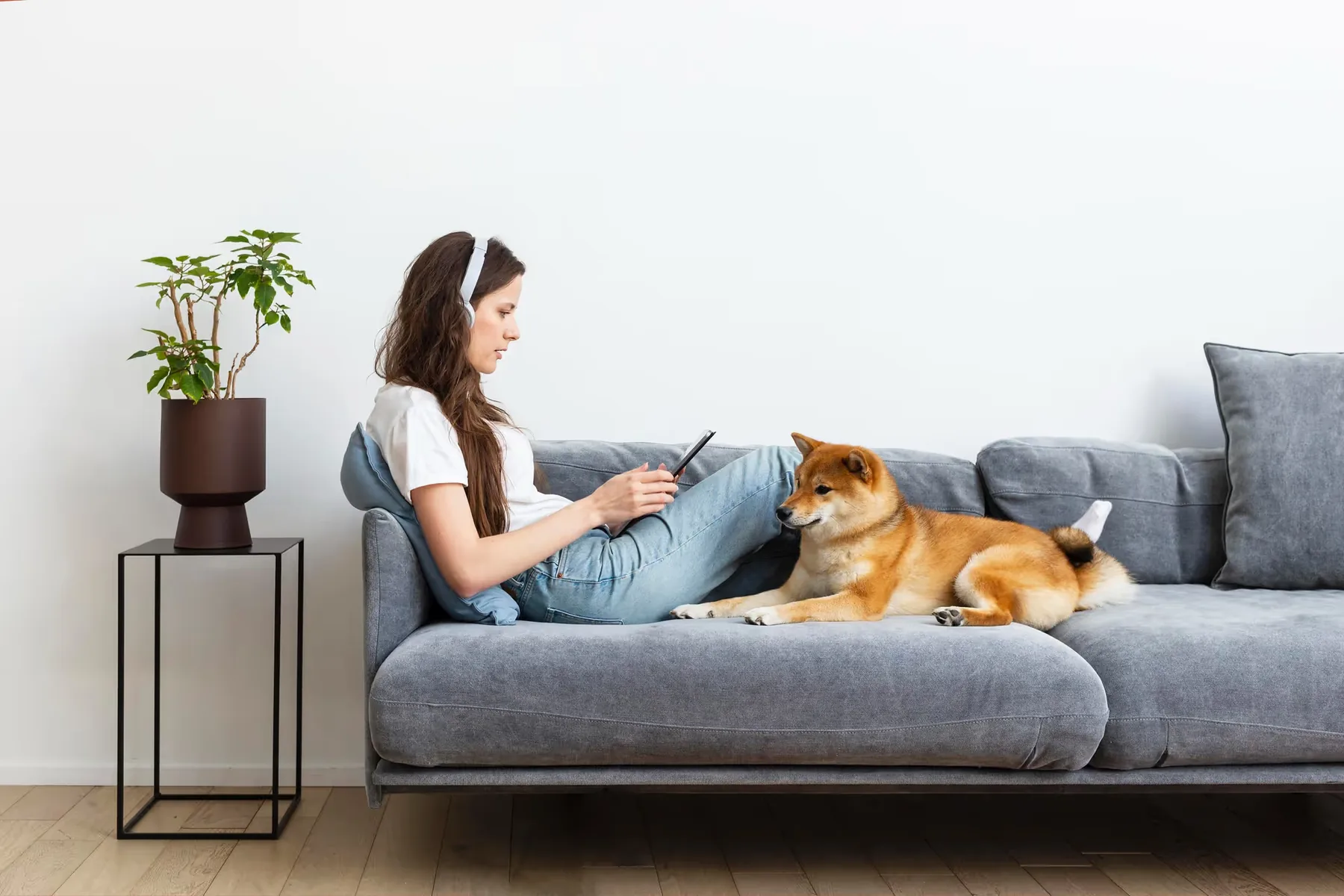 A woman and her dog relaxing on a sofa in a fresh living room