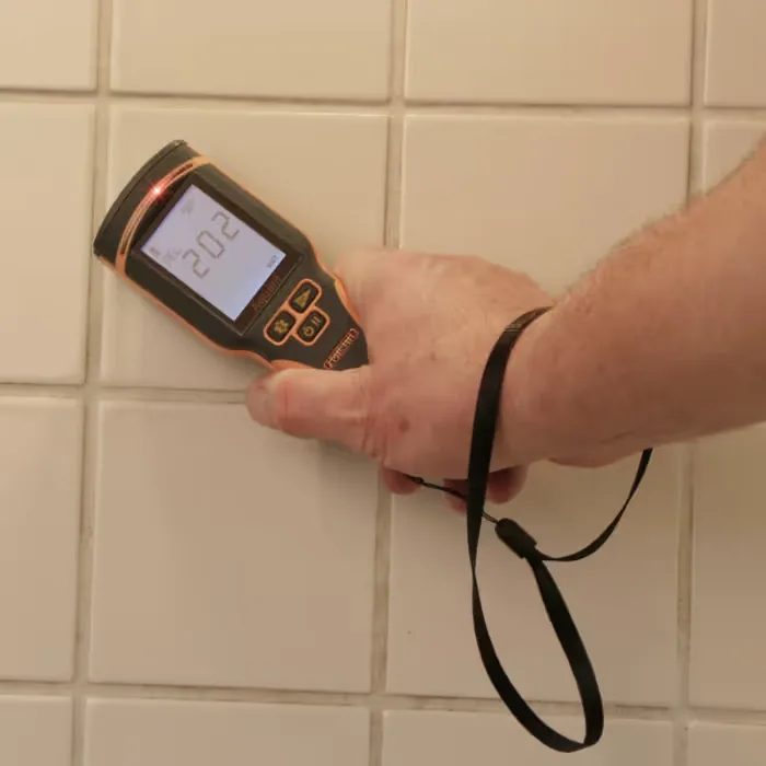 Checking moisture in a tiled wall with a moisture meter