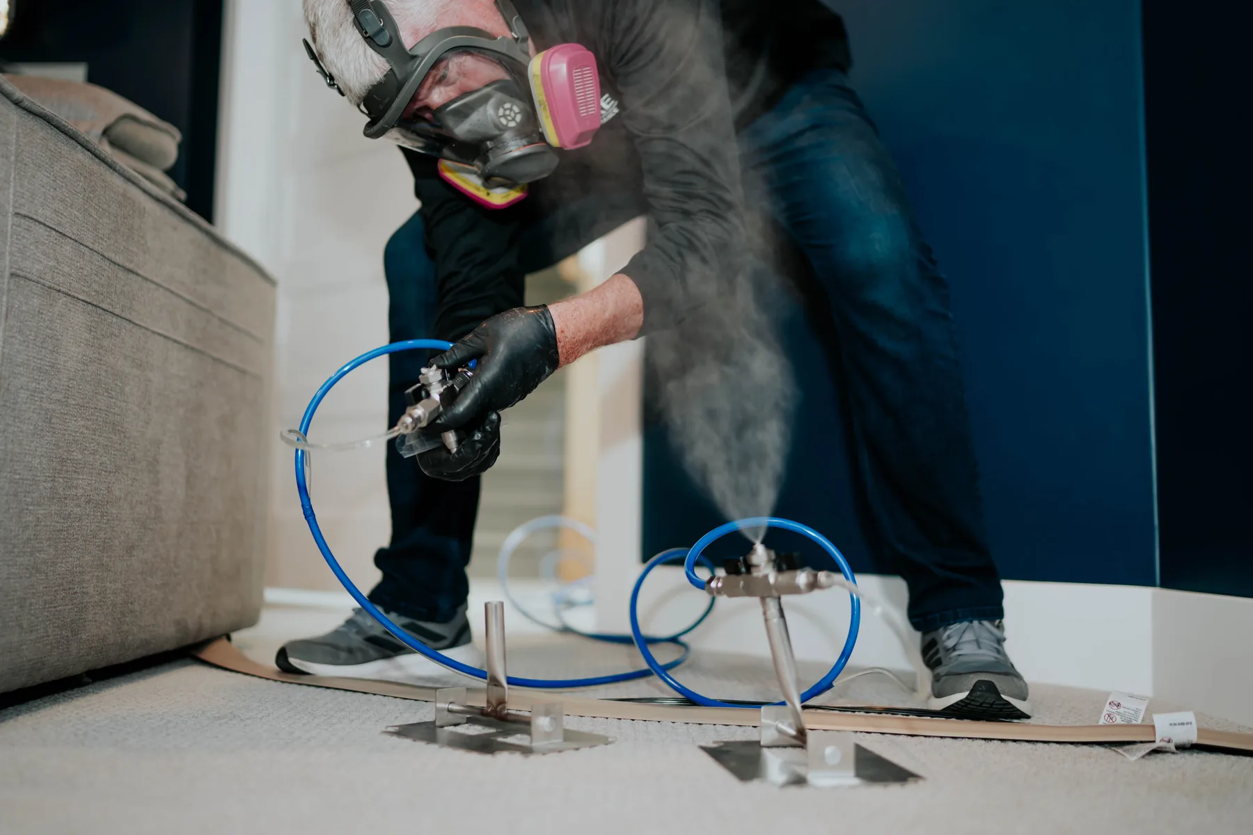 A technician in a respirator running vapor equipment